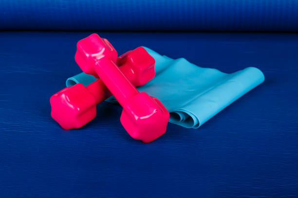 istock Rubber Band and Pink Dumbbell on Pilates Mat 874398340
