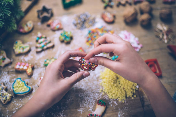 istock female hands decorating christmas cookie on wooden table 874398874