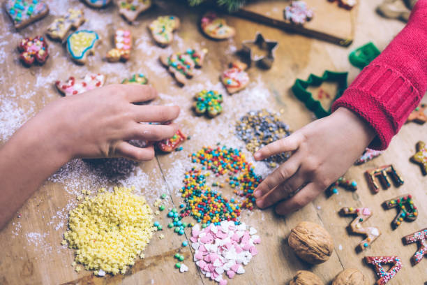istock young hands decorating christmas cookies together 874402028