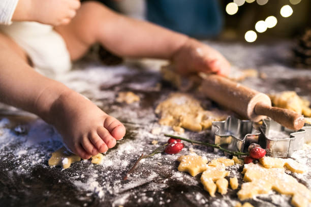 familia joven hacer galletas de jengibre en casa. - christmas child cookie table fotografías e imágenes de stock
