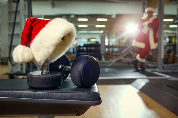 gorro de santa en el gimnasio. - holiday healthy lifestyle weight christmas fotografías e imágenes de stock