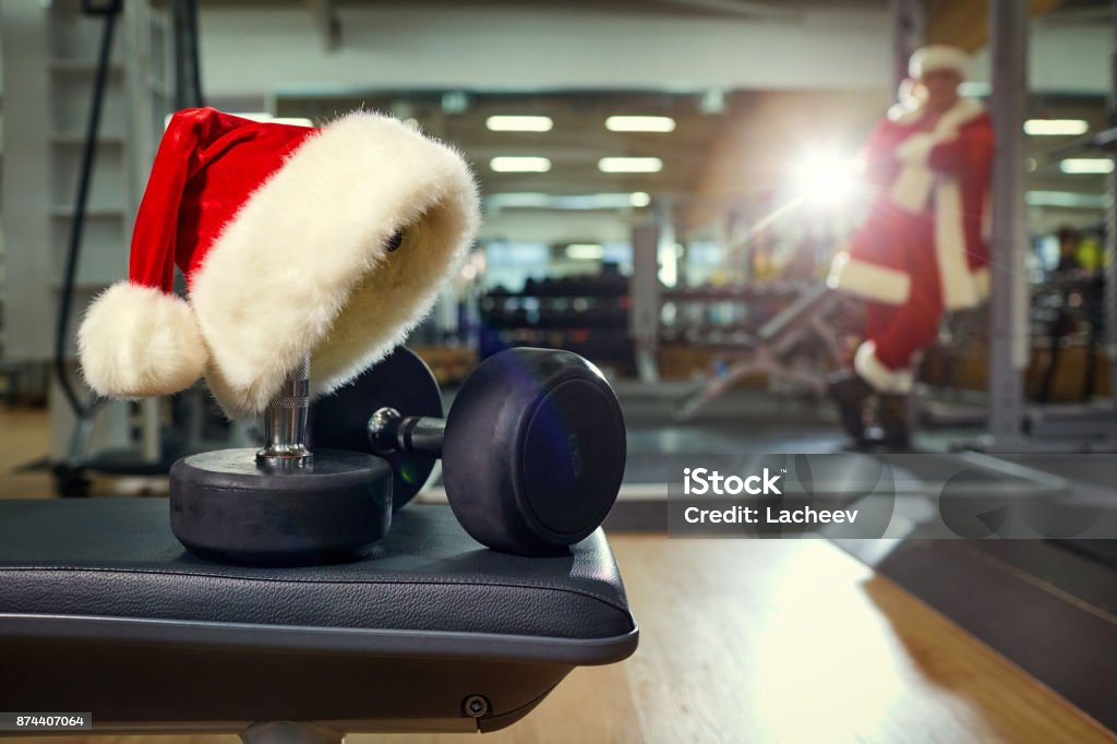 Santa's hat in the gym. Santa's hat in the gym. Concept of sports on Christmas and New Year. Christmas Stock Photo