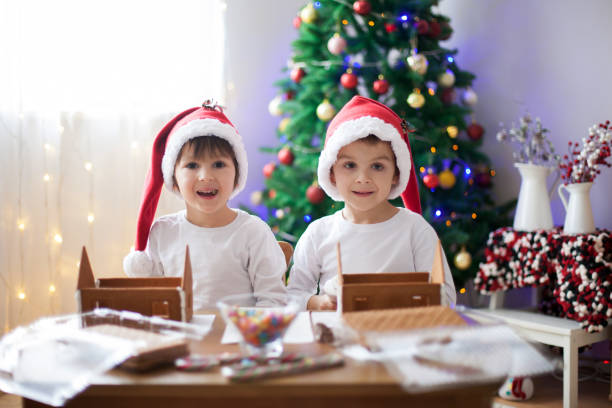 istock Two sweet boys, brothers, making gingerbread cookies house 874413552