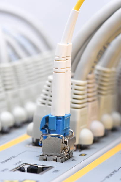 istock Optic fiber and network cables connected to switch in data center 874418082