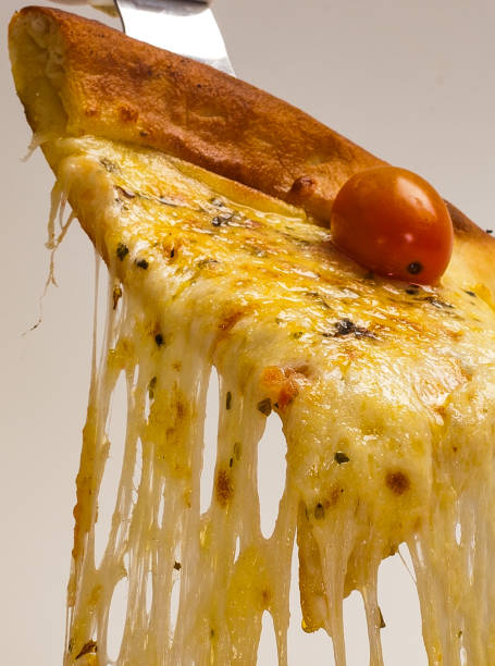 Slice of hot pizza being served with mozzarella cheese melting