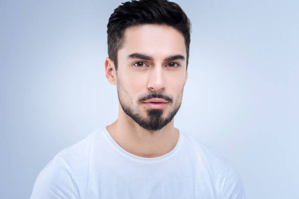 istock Handsome young man standing against the blue background 874423856
