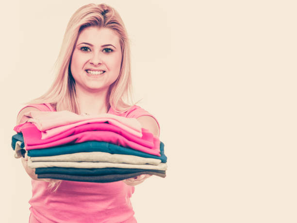 istock Woman holding pile of folded clothes 874426578