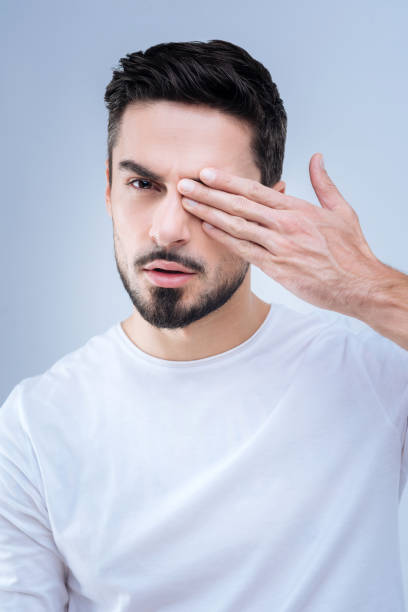 istock Serious man closing his eye and realizing the condition of his eyesight 874427736