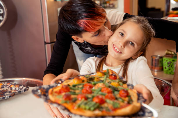 istock Mother and Daughter Making Christmas Pizza Together 874428162