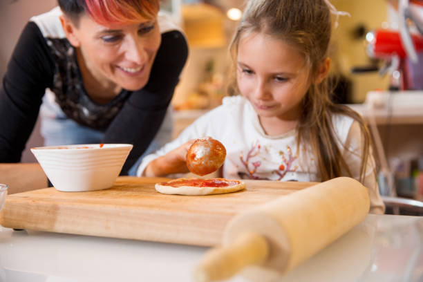 istock Mother and Daughter Making Christmas Pizza Together 874428242