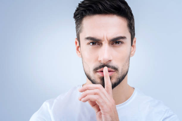 istock Young handsome teacher asking his pupils to be quiet 874428360