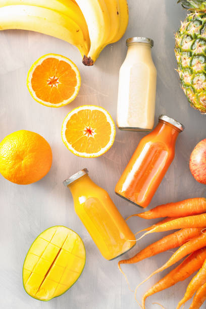 istock fruit and vegetable smoothies in glass jars, orange mango banana carrot pineapple 874428804