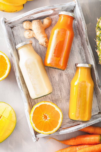 istock fruit and vegetable smoothies in glass jars, orange mango banana carrot pineapple 874431312