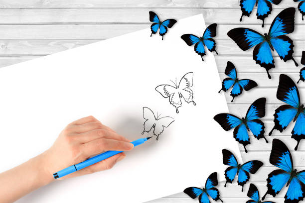 istock Drawing butterflies on white paper 874438130