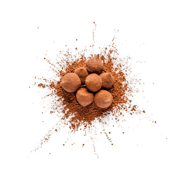 Chocolate truffles and cocoa powder heap shot from above on white bachground Top view of a heap of organic cocoa powder with chocolate truffles on it shot on white background. DSRL studio photo taken with Canon EOS 5D Mk II and Canon EF 100mm f/2.8L Macro IS USM chocolate truffle stock pictures, royalty-free photos & images