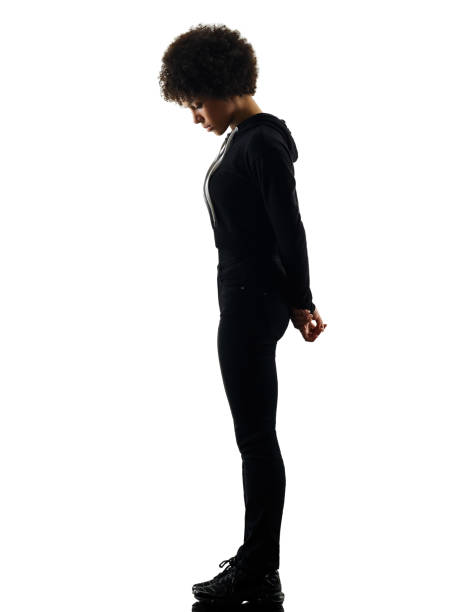 giovane adolescente ragazza donna in piedi tristezza ombra silhouette iso - guardare verso il basso foto e immagini stock