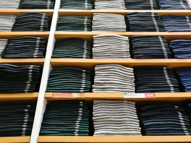 istock Piles of men's sweaters stacked on shelves inside store 874449916