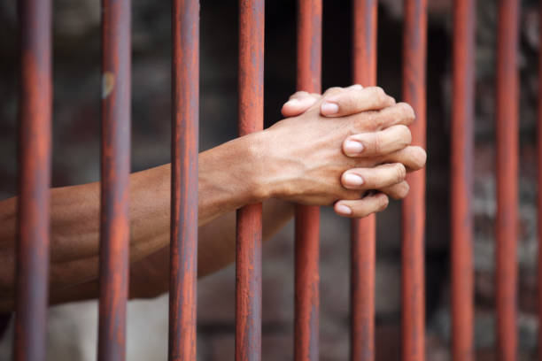 istock hands of prisoner in jail 874454438