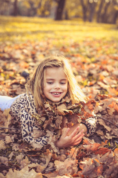 istock Happy little girls on fallen leaves. 874456492