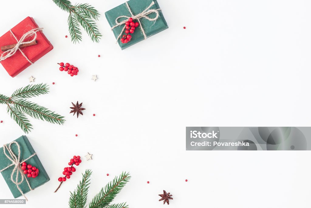 Christmas gifts on white background. Flat lay, top view Christmas composition. Frame made of christmas gifts, pine branches, toys on white background. Flat lay, top view, copy space Christmas Stock Photo