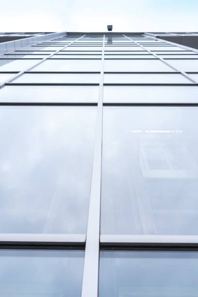 istock Shooting from lower angle close-up large glass windows of multi-storey office building. 874460902