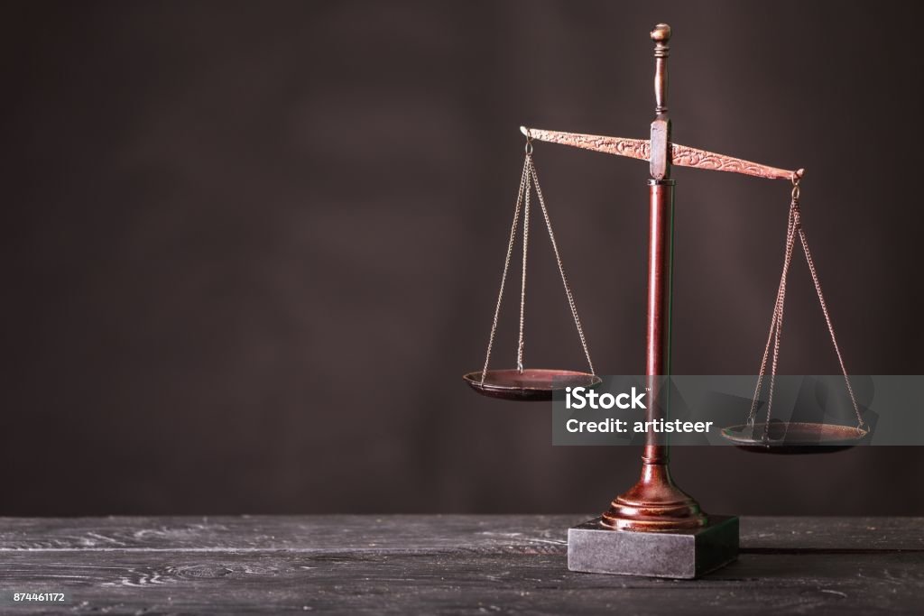 Legal. Law scales on table on dark background Weight Scale Stock Photo