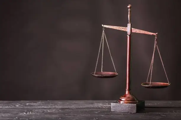 Law scales on table on dark background