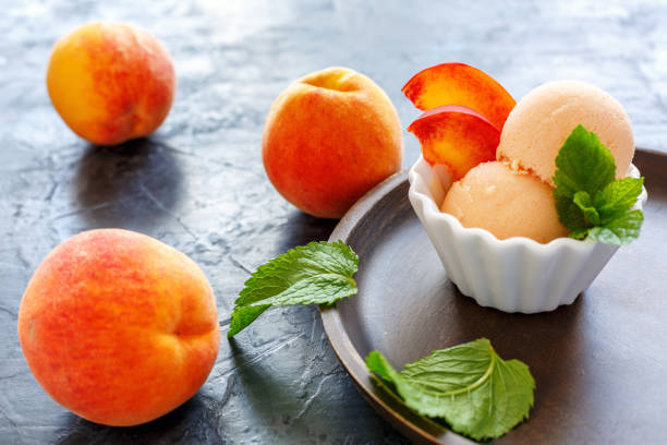 istock Balls peach ice cream in a white bowl. 874463826