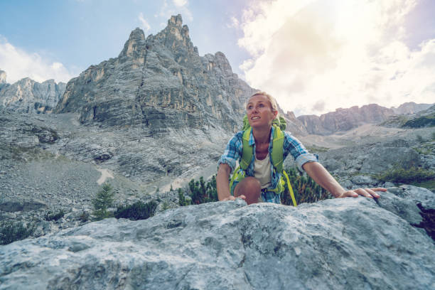 istock Climber female reaching mountain top, Dolomites, Italy 874475070