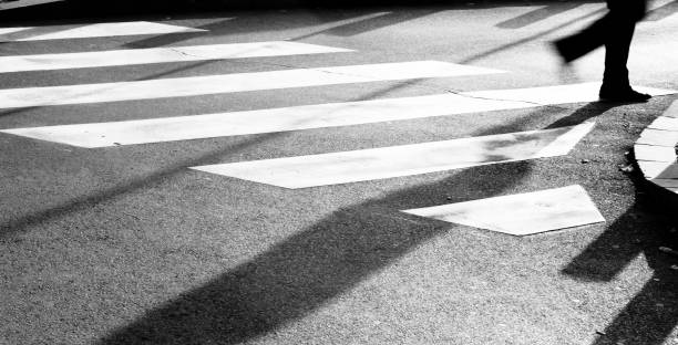 istock Blurry zebra crossing with person silhouette and shadow 874481906