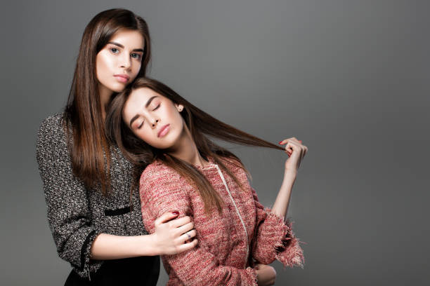portrait of beautiful twins women with  natural make-up and long hair. fashion