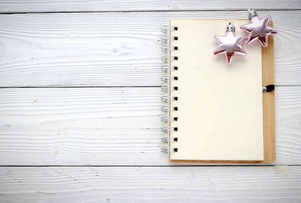 istock holiday decorations and notebook on white wood background 874485286