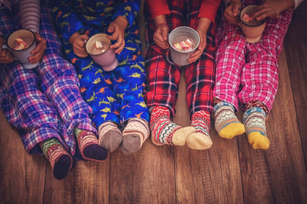 bambini carini in pigiama e calze natalizie che bevono cioccolata calda con marshmallow per natale - christmas child foto e immagini stock