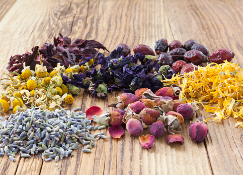 Hibiscus, rose hips, chamomile, mallow, lavender, rose buds ans marigold on wooden background