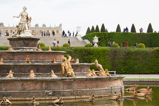 VERSAILLES, FRANCE - April 14, 2015: The Latona Fountain in the Gardens of Versailles with the Palace of Versailles in the background