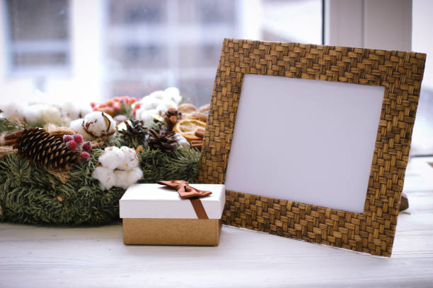 istock Desktop photo frame, christmas wreath and gift box on white sill 874487964