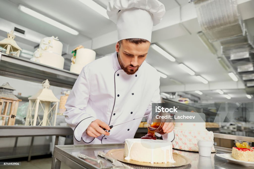 A confectioner with a cake in the bakery A confectioner with a cake in the bakery. Cake Stock Photo