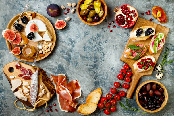 istock Appetizers table with italian antipasti snacks. Brushetta or authentic traditional spanish tapas set, cheese variety board over grey concrete background. Top view, flat lay 874498544