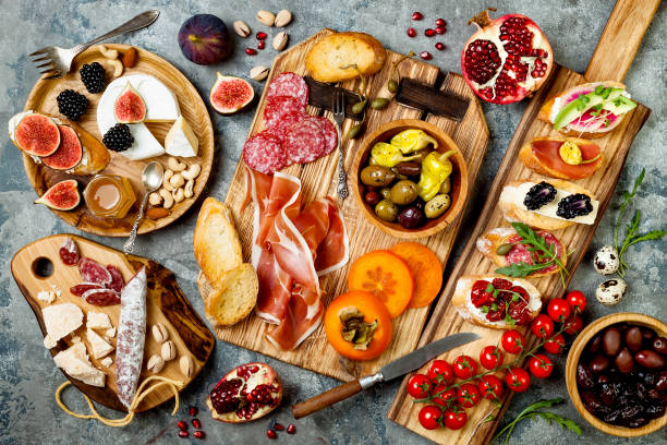 tabla de aperitivos con aperitivos de antipasti italiano. sistema de brushetta o auténticas tapas españolas tradicionales, tabla de variedad de queso sobre fondo de hormigón gris. vista superior, endecha plana - antipasto fotografías e imágenes de stock