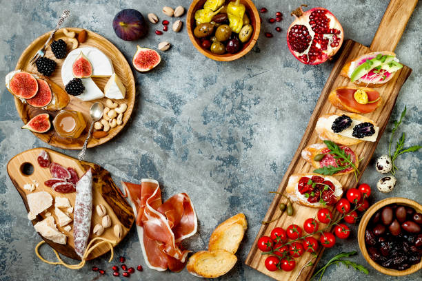istock Appetizers table with italian antipasti snacks. Brushetta or authentic traditional spanish tapas set, cheese variety board over grey concrete background. Top view, flat lay 874501012