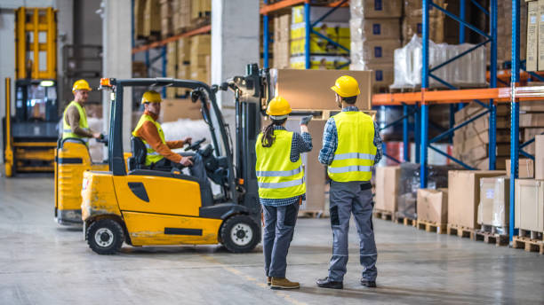 operai che lavorano in magazzino - warehouse interior foto e immagini stock