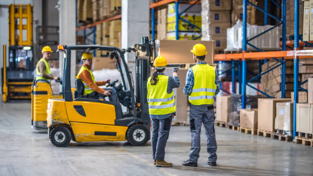 Manual workers working in warehouse Male and female worker working in warehouse. forklift photos stock pictures, royalty-free photos & images