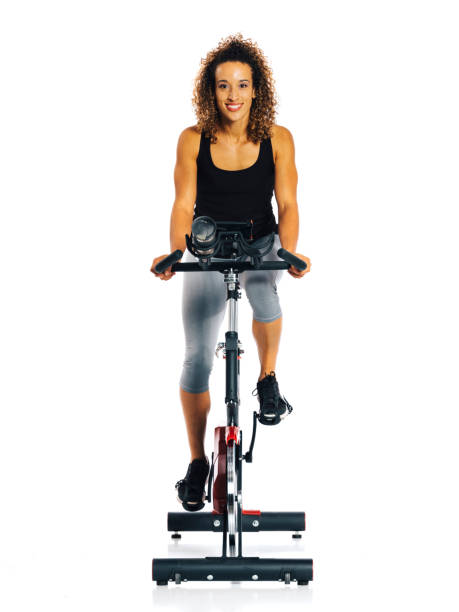 woman on an exercise bike - bicycle women cycling gym imagens e fotografias de stock