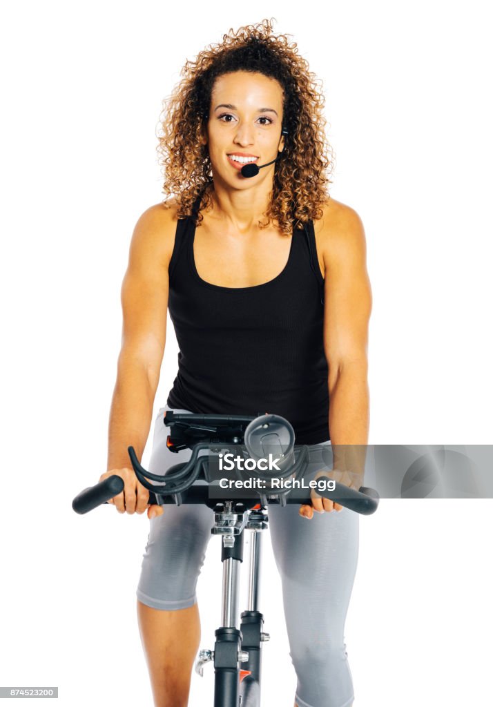 Woman on an Exercise Bike A woman exercising on a stationary bicycle against a white background. Fitness Instructor Stock Photo