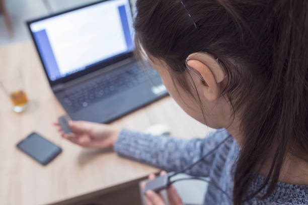 Happy with Roger clip-on mic Young girl with hearing aid and modern technology assistive technology stock pictures, royalty-free photos & images
