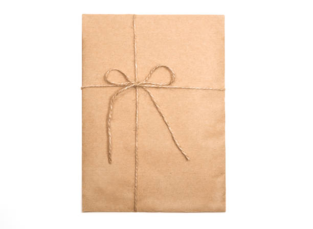 papier kraft enveloppe ficelés sur fond blanc - wrapped package string box photos et images de collection