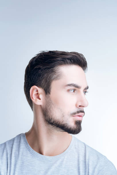 istock Calm handsome man turning left and thinking while sitting at home 874537352