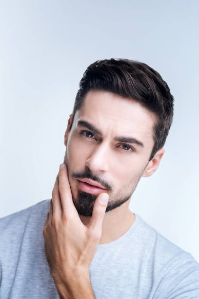 istock Skilled professional barber thinking of a haircut for his client 874537670