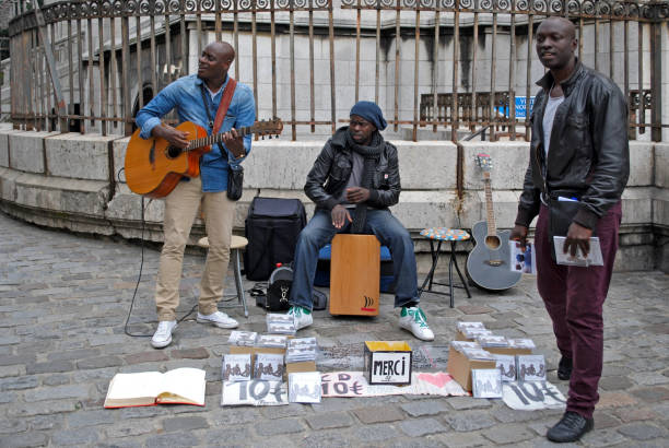 Paris, France - August 15, 2015: Vendor sets up Eiffel Tower souvenirs on a mat in front of Sacre-Coeur Basilica which is one of the most popular tourist destinations in the city.