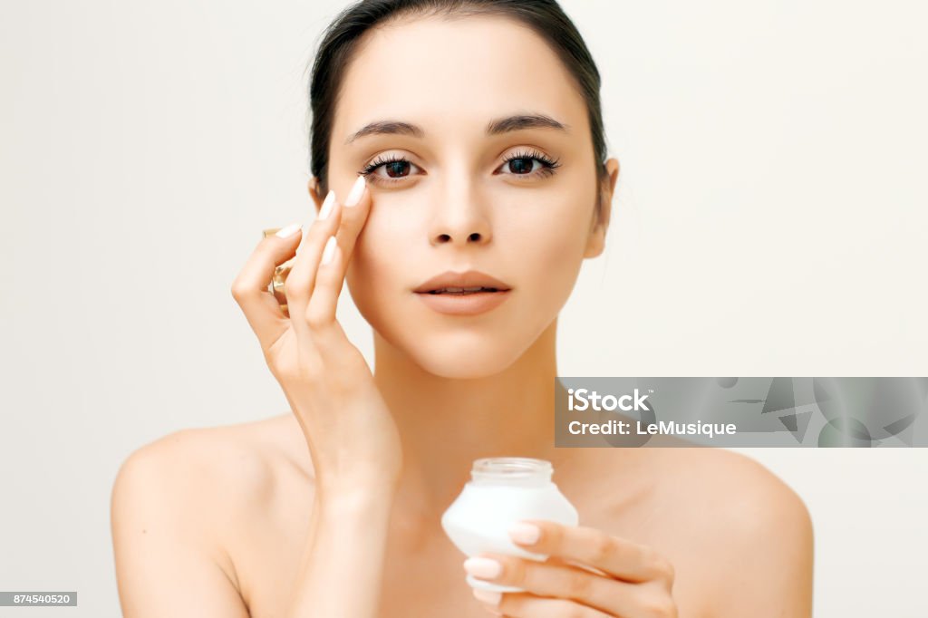 Portrait de la beauté naturelle de la jeune femme, appliquer la crème sur son visage - Photo de Oeil libre de droits